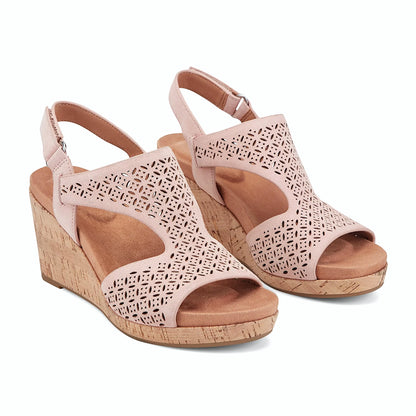 Close view of the geometric floral perforation across a wedge sandal strap