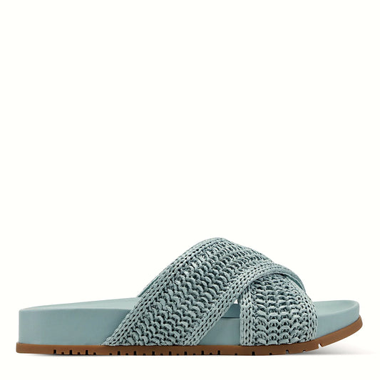 Side view of a medium blue slide sandal with crisscross straps