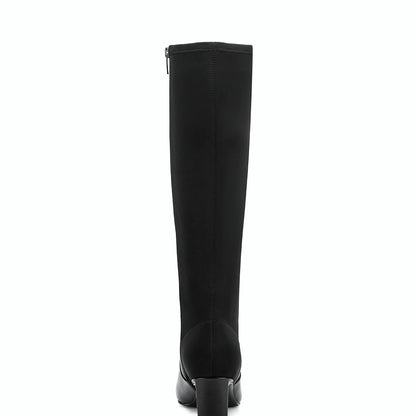 Rear view of a tall dress boot showing the sculpted block heel