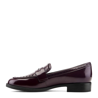 Pair of brogued penny loafers photographed from above on a plain background
