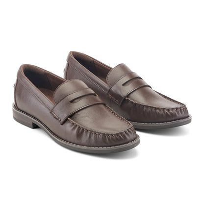 Angled view of a penny loafer showing gathered moc-toe seaming and a low stacked heel