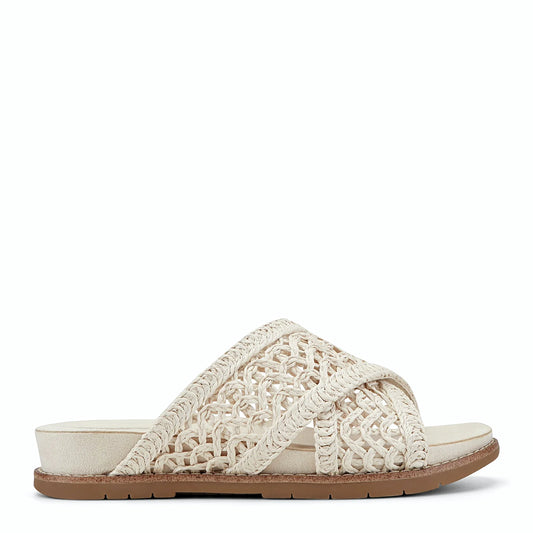 Side view of an ivory slide sandal with an open lattice upper